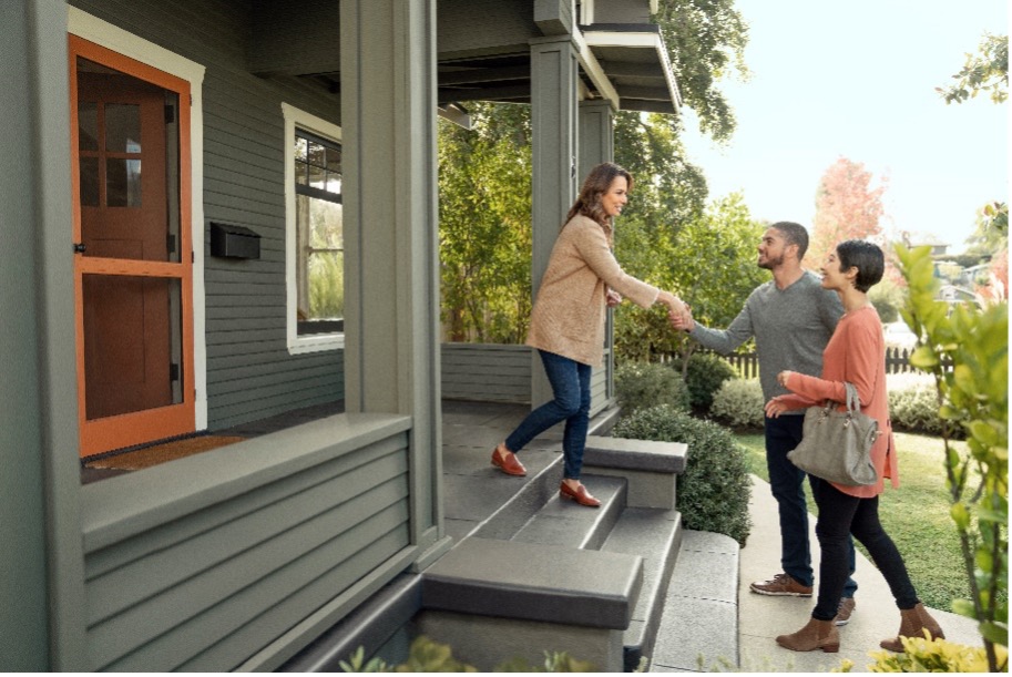 couple greeting woman on porch