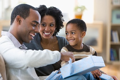 family opening gifts on the couch