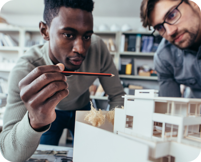 Two men looking at a model of a building.